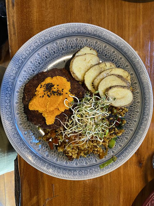 Aduki bean burger patties with carrot cream, rice, sautéed veggies and baked potato  at Curcuma in El Chalten
