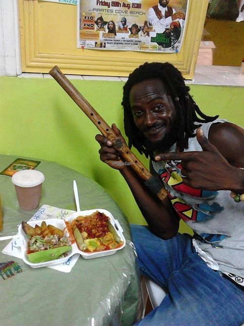 An Artists spot where great food is available. The Flute man is enjoying a delicious meal. at Roots Reggae Vegetarian Cafe in Bridgetown