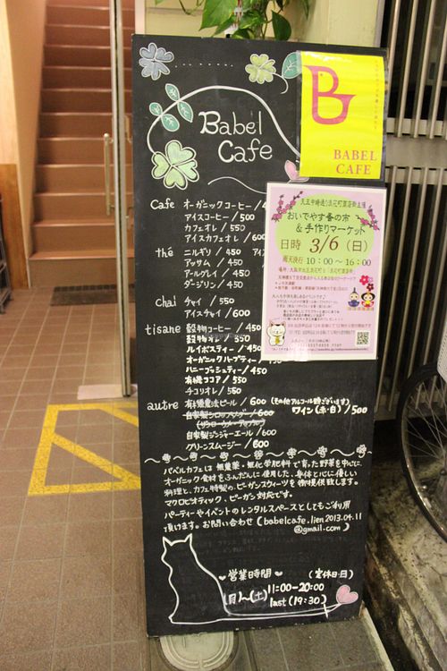 Babel cafe sign outside with drinks menu and event poster. at Babel Cafe in Osaka