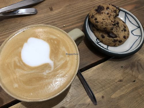 Latte with almond milk and cookies  at La Studio in Hanoi