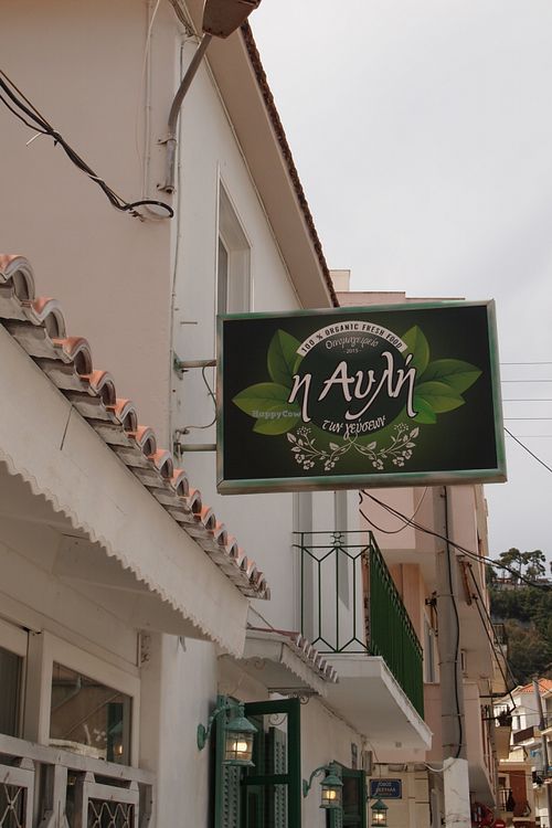 Outdoor sign in Greek, translating as 'Yard of Taste' at Yard of Taste in Zakynthos