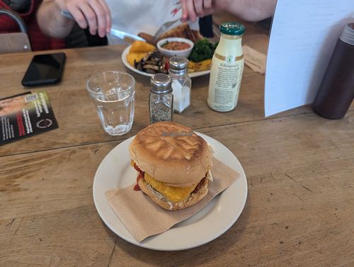 Breakfast bap/bun and large breakfast behind at Cafe Kino in Bristol