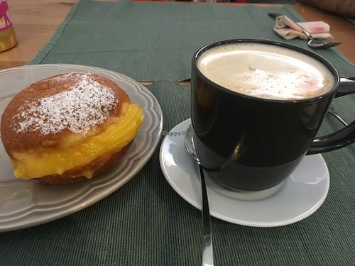 Oath and coffe with a Bola de berlin at Green Beans in Lisbon