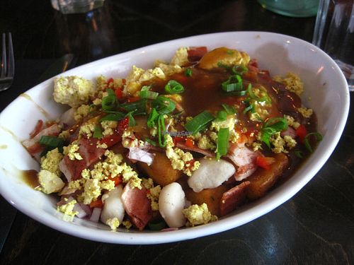 Breakfast poutine with extra vegan cheese and vegan bacon. It was pretty good, but way too salty for my taste buds. at L'Gros Luxe 100% Vege in Montreal