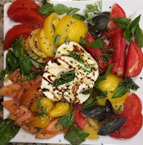 Summer Tomato Salad. 5 varieties of basil and sun ripened tomatoes. 15 year aged balsamic vinegar and Greek olive oil drizzle.  at Guernsey Kitchen in Cambridge