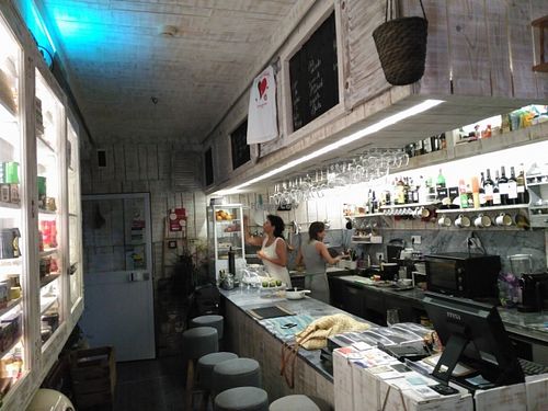 Bar seating and kitchen at O Xexexe in Costa Da Caparica