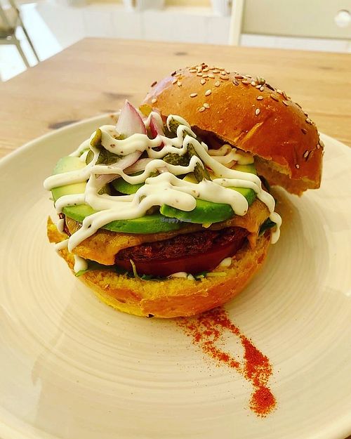vegan mushroom and lentil burger loaded with avocado, vegan cheese, Gherkins and vegan garlic mayo in a turmeric bun at Cocos Deli in Mallorca