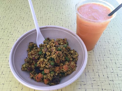Dish with millet, sorgo, beans and vegetable seasoned with curry powder. Juice with orange, carrot, apple and ginger  at Zazie in Ferrara