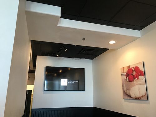 TV in the back playing upbeat music at Cinnaholic - Grand Canyon Dr in Las Vegas