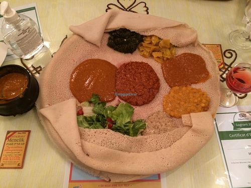 The two vegan dishes (see menu photo for details) served together on one injera. The container at left holds more of the "chouro" dish. Not shown is the additional bread this comes with. at Menelik in Paris