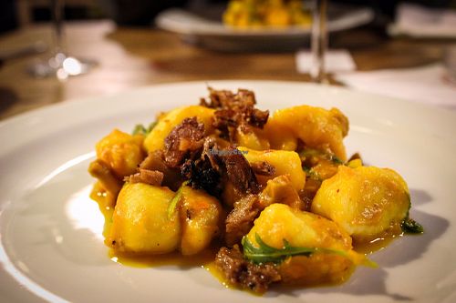 gnocchi with pumpkin sauce, saffron, rocket, rawmesan and seitan at Incruenti in Prague