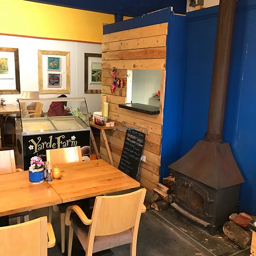 wood stove and local artwork on the walls at Wood and Green Cafe in Wadebridge