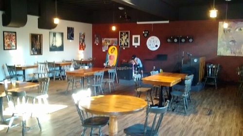 Cafe setting, local artist work on walls for sale, stage for events at Black Sheep Lounge in Welland