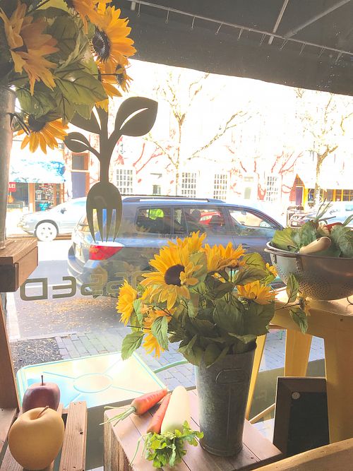 A sunny view of market street from the window counter at Tossed on Market in Corning