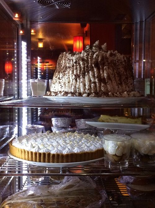 A gigantic vegan black forest cake (chocolate and berries) and vegan lemon meringue pie, waiting for us in the restaurant's dessert case. at L'Apollinaire in Paris