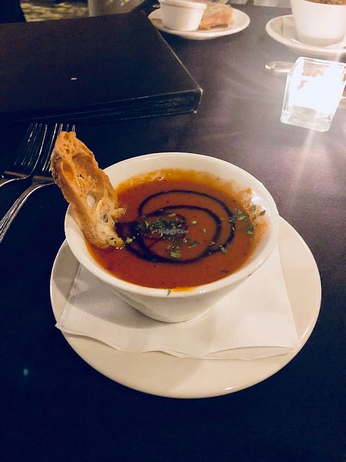 Yummy tomato red pepper bisque. I didn’t eat the bread I’d ask if it’s vegan!  at River City Grill in Yuma