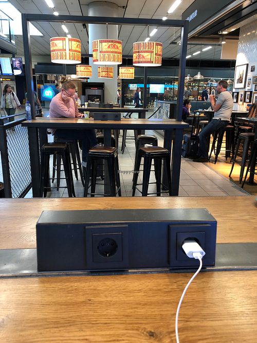 Charging sockets on the tables in the back at AMS - LEON in Schiphol