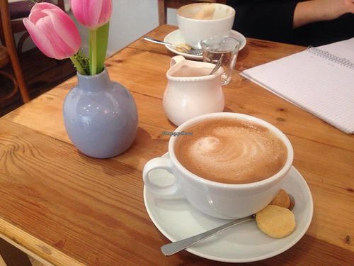 Cappuccino with oat milk + mini vegan biscuits  at Cafe Con Amore in Berlin