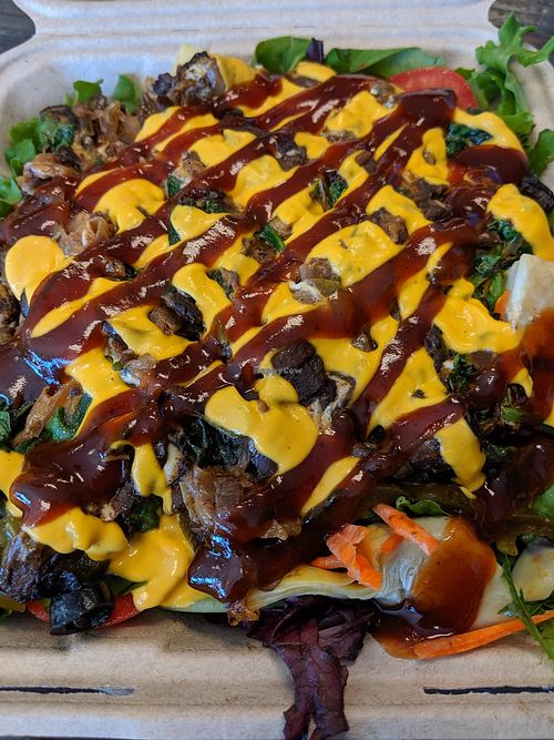 Spinach mushroom melt on salad base of kale, spring blend,  artichokes, jalapenos, olives, carrots, tomatoes, dried cranberries, pepitas, onions, smoked cabbage with house BarBQ &  at The Veg Hub in Oakland