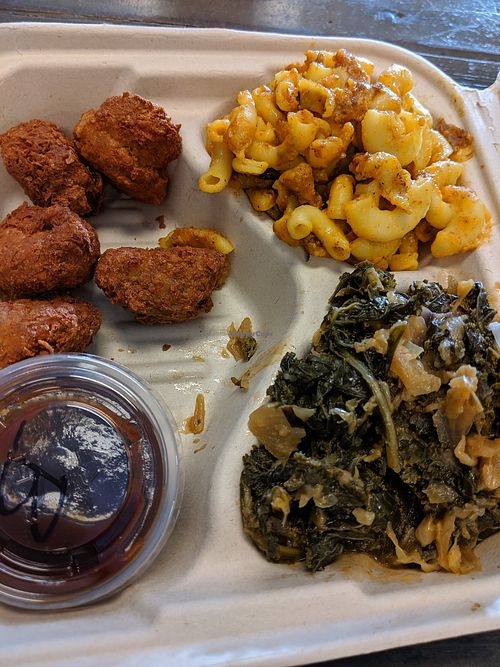Fried chicken plate with sides of collard greens, creamy Mac & cheese, BarBQ sauce at The Veg Hub in Oakland