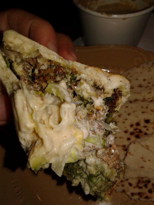 An up-close of the falefal sandwich with pickled turnips, onion, lettuce, think sauce, falafels, hummus, and pita at Saca's Mediterranean Cuisine in Claremont