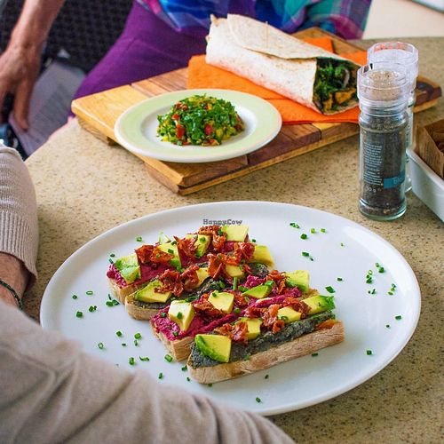 Top: Our best-selling Stir Fried Kale Wrap with Indonesian herbs, caramelised onions, roasted almond and smokey tofu. Served with a side salad.
Bottom: Our Pink & Black Hummus breakfast toast with Avo & Sundried Tomatoes on a bed of rocket at Namaste Lifestyle Cafe in Western Cape