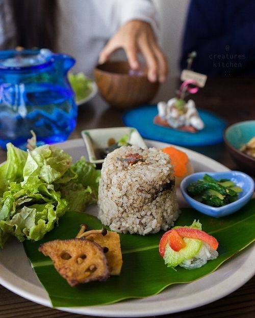 Lunch set featuring brown rice and pickled plum, lotus root, greens, eggplant, komatsuna, miso soup, and tofu.  at Imacoco in Okinawa