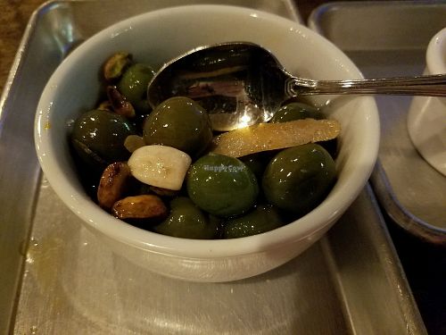Warm Olives with rosemary, roasted garlic, pistachios and lemon infused olive oil. Delicious! at Donna Jean in San Diego