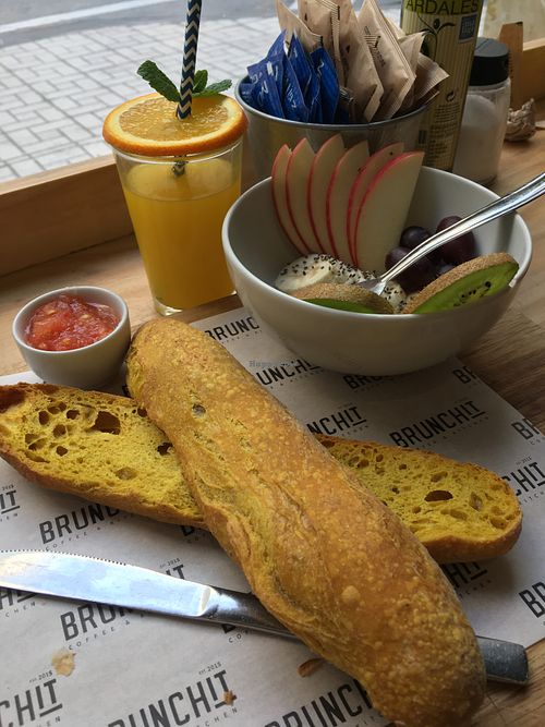 Combo vegano desayuno: pan de cúrcuma con tomate y aceite, zumo, fruta y café con leche de soja at Brunchit in Malaga