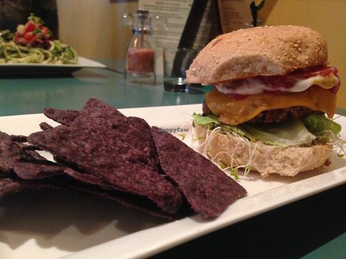 Macro Burger with cheez! Love everything about this meal. The chips were light and fresh, as well as the flavor was on point in the black bean/sweet potato, rice patty! at The Present Moment Cafe and Market in St Augustine