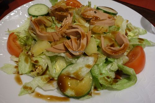 Hawaii Salad with iceberg lettuce, cucumber, tomatoes, vegan bacon, and pineapple (vegan) at Veggie House in Saarbrucken