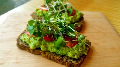 Meg's toast: House-made gf seed and nut bread topped with avocado, lemon juice, tomato, home-grown sprouts, salt and pepper. at Surya Cafe in Fitchburg