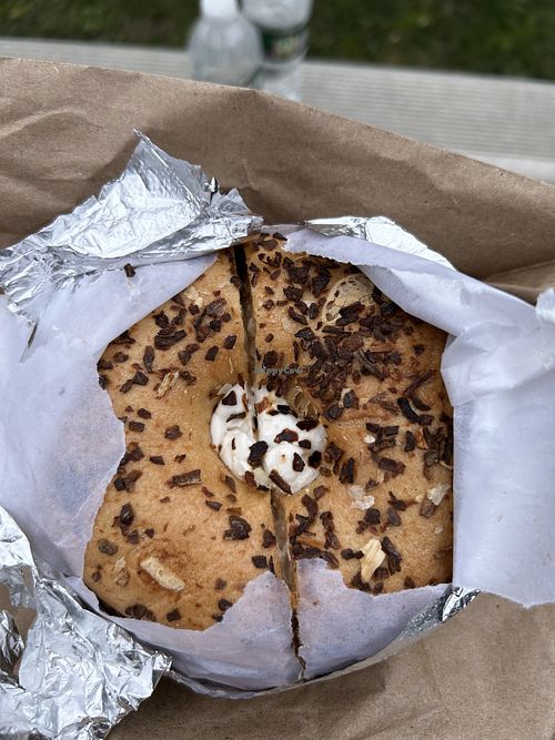 Onion bagel toasted with vegan plain cream cheese  at Bare Naked Bakery in Bellmore