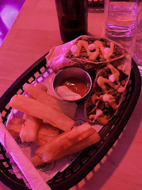 Burrito with yucca fries, yummy cashew cream drizzle  at Huacamole Vegan Food in San Pedro